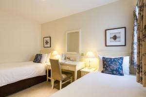 a hotel room with two beds and a desk at Abbey Fields By Chef & Brewer Collection in Kenilworth