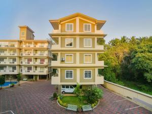 a large yellow building with a car parked in front of it at The Avenue Orlim in Cavelossim
