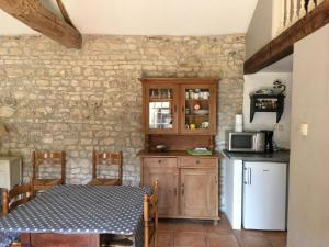 a kitchen with a table and a counter with a microwave at Le Pigeonnier in Landrais