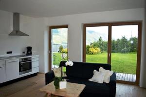 a living room with a couch and a table and a kitchen at Weingut Bachgütl in Cermes