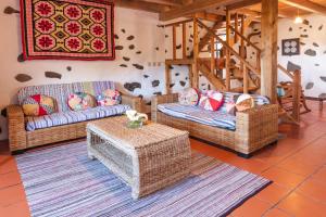 a living room with three couches and a table at Aldeia da Cuada in Faja Grande