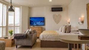 a bedroom with a bed and a tv on the wall at St Annes Beach Apartments in Lytham St Annes