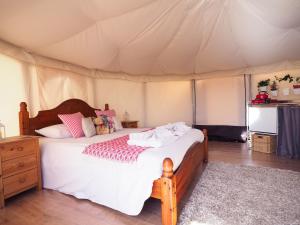 a bedroom with a bed in a tent at Old Dairy Farm Glamping in Emsworth