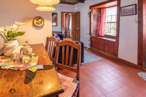 a wooden table and chairs in a room with a dining room at Aldeia da Cuada in Faja Grande