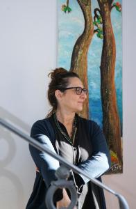 une femme assise devant un tableau dans l'établissement Locanda degli Alberi, à Sassetta