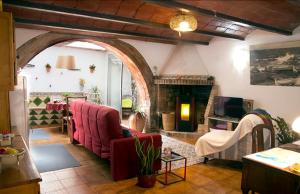sala de estar con sofá rojo y chimenea en Ca la Teia, en Bellcaire dʼEmpordà