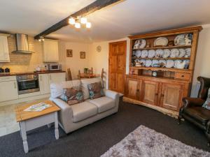 ein Wohnzimmer mit einem Sofa und einem Tisch in der Unterkunft The Stable Cottage in Llanbedr