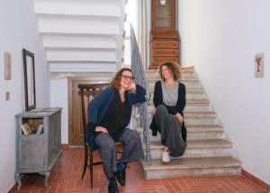 薩塞塔的住宿－Locanda degli Alberi，坐在房子楼梯上的两名妇女