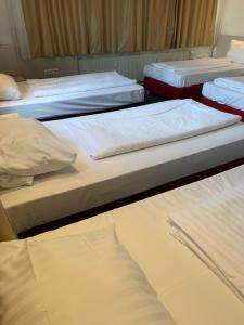 a group of three beds in a room at Hotel New Fair Munich Messe in Munich