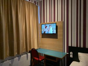 a room with a television in a hotel room at Hotel New Fair Munich Messe in Munich +20 photos