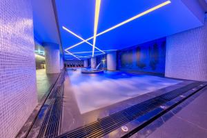 a swimming pool in a building with blue lights at Meliá Maputo Sky in Maputo