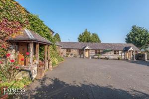 an exterior view of a house with a driveway at Highgrove Barns in Craven Arms