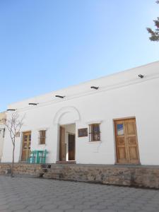 a white building with wooden doors and windows at Hosteria Villa Cardon in Cachí