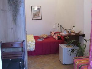 Un dormitorio con una cama con una colcha roja y una mesa. en Puesta De Sol, en Tramonti