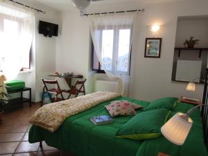 Un dormitorio con una cama verde y una mesa en Puesta De Sol en Tramonti