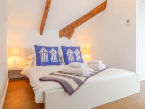 a bedroom with a bed with blue and white pillows at The Loft at Beach House in St Austell