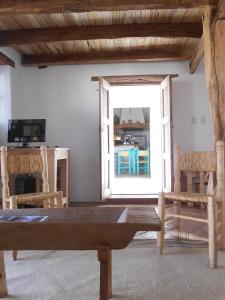 sala de estar con mesa de madera y sillas en Hosteria Villa Cardon en Cachí