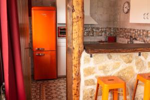 a kitchen with an orange refrigerator and a counter at Las Casitas de la Data in Gallegos