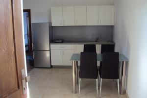 a kitchen with a table and chairs and a refrigerator at Motel Senec in Senec