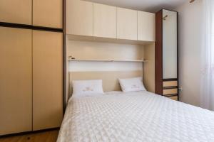 um pequeno quarto com uma cama e armários em Casa Sofia em Vrsar