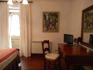a bedroom with a desk with a computer and a bed at Pazo Carrasqueira in Ribadumia