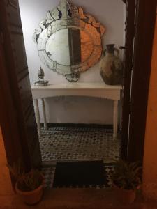 a hallway with a mirror and a table with plants at Dar Iman in Fès