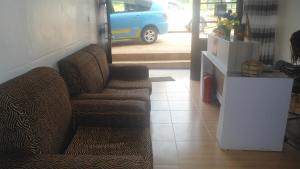 a living room with a couch and a blue van at AIRPORT INN MOTEL in Kigali