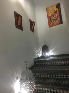 een kamer met een trap met twee lichten en een foto aan de muur bij Dar Iman in Fès