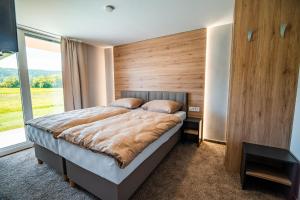 a bedroom with a large bed with a large window at Guesthouse Mars in Ig