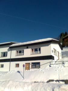 a white house with snow in front of it at Berg & Skihütte -Schmittenhof in Laterns