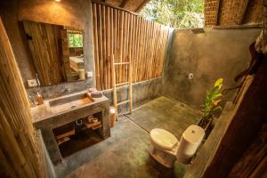 een badkamer met een wastafel, een toilet en een spiegel bij Musa Villas and Bungalows Gili Air in Gili Air