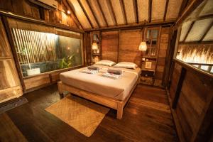 a bedroom with a bed and a large window at Musa Villas and Bungalows Gili Air in Gili Air
