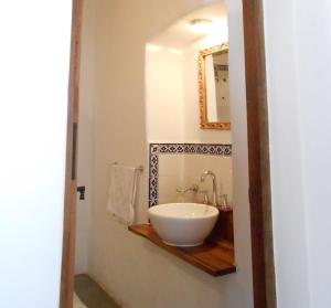 a bathroom with a bowl sink and a mirror at Hosteria Villa Cardon in Cachí