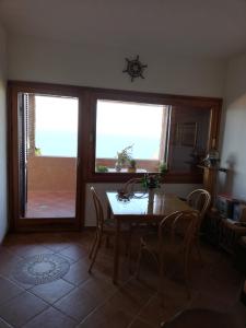 a dining room with a table and two windows at Una terrazza in Paradiso in Costa Paradiso +45 photos