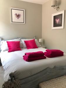 a bedroom with a large bed with red pillows at Boutique Townhouse in Christchurch Dorset in Christchurch