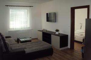 a living room with a couch and a table and a bed at Motel Senec in Senec