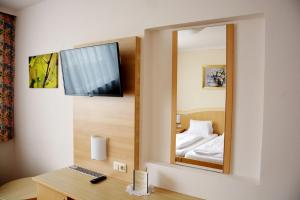 a mirror in a room with a bed and a desk at Gasthaus & Gästehaus Bsteh in Wulzeshofen