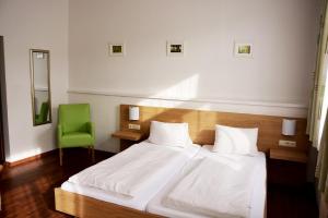 - une chambre avec un lit et une chaise verte dans l'établissement Gasthaus & Gästehaus Bsteh, à Wulzeshofen
