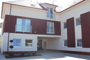 a large white and brown house with a driveway at Motel Senec in Senec