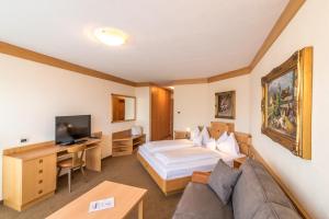 um quarto de hotel com uma cama e uma secretária em Taushof em Scena