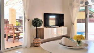 a living room with a tv and a table at Palm Paradise Villa in Ayia Napa