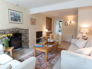 ein Wohnzimmer mit Couch und Kamin in der Unterkunft Jot Cottage in Salcombe
