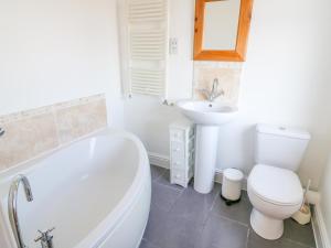 a bathroom with a tub and a toilet and a sink at Langtree in Carnforth