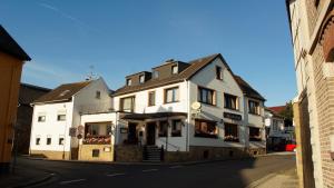 ein weißes Gebäude an der Straßenseite in der Unterkunft Hotel Rosenflora in Nideggen