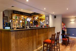 a bar in a pub with two chairs and a counter at Nelthorpe Arms in Barton-upon-Humber
