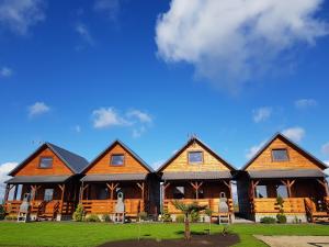 a large log cabin with a blue sky in the background at Osada Chłapowo in Władysławowo