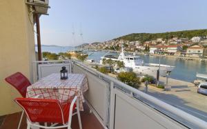 een balkon met een tafel en stoelen en een boot bij Apartments Ive - with sea view in Tisno