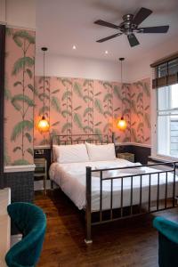 een slaapkamer met een bed met tropisch behang bij Crown Hotel in Stamford