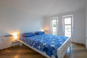 1 dormitorio con cama azul y almohadas azules en Apartment Vita, en Rijeka