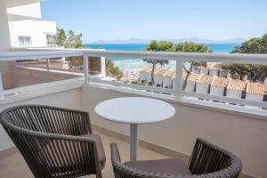 a balcony with a table and chairs and the ocean at Grupotel Los Príncipes & Spa in Playa de Muro